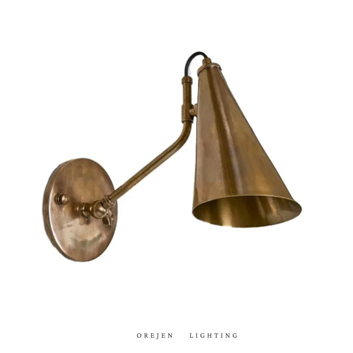 A wall-mounted light fixture with a brass finish and a conical shade.