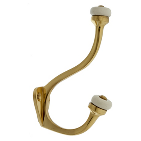 A solid brass hook with a porcelain tops on the curved portion, designed for hanging items such as robes.